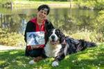 Author Michelle LeFevre holding her book "On Kona's Pond" sitting next to her dog, Kona.